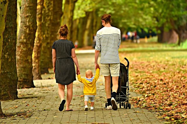 Couple walking with their baby while hold the baby's hands