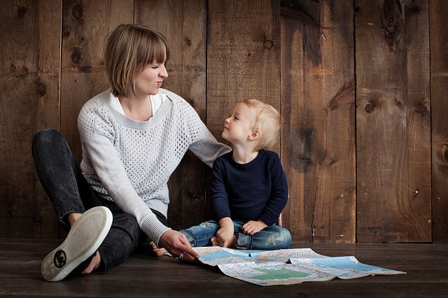 Mother and son are both looking at a map sitting on the floor