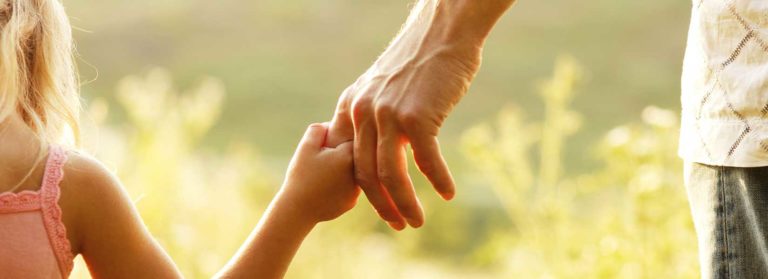A picture of a girl holding her dad's finger